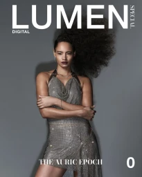 Model in a glittering silver chainmail dress posing against a solid grey studio backdrop with magazine title text at the top