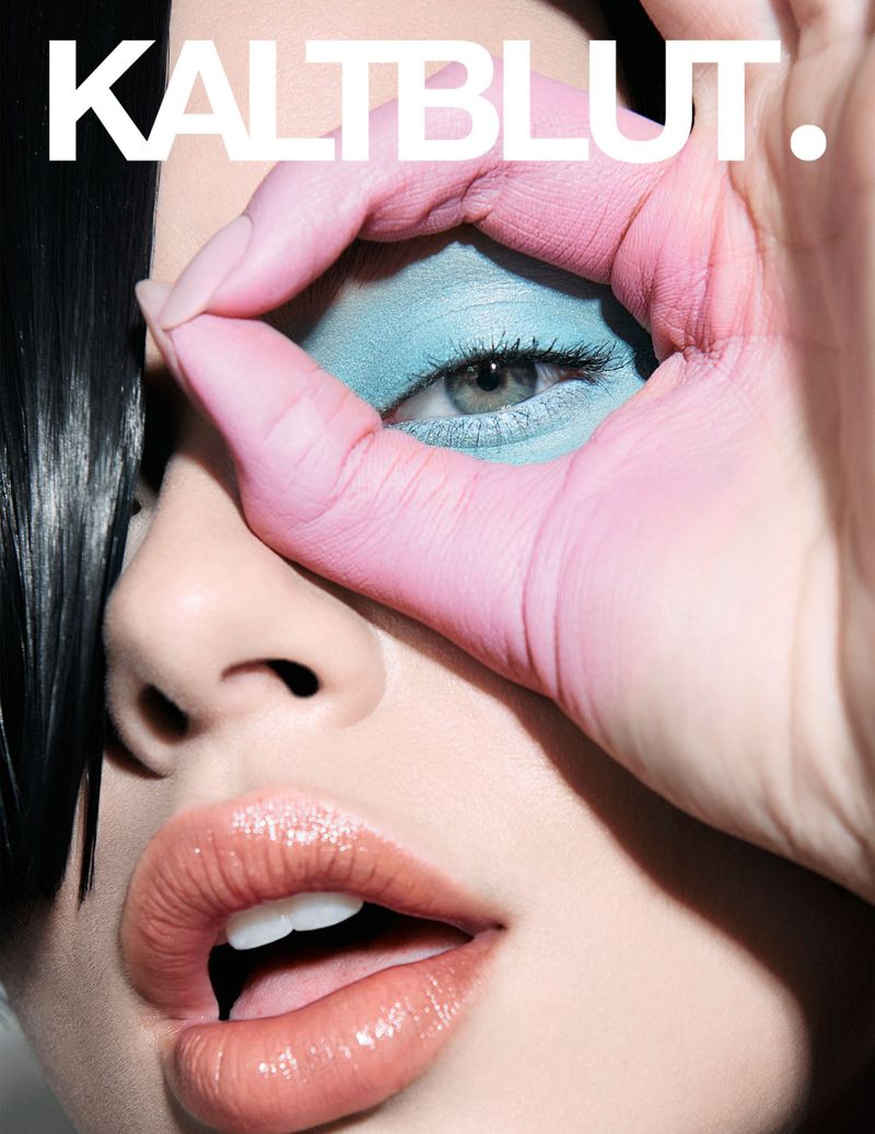 Magazine cover featuring an adult female model with painted hands forming a circle around her eye and bold text overlay.