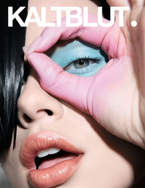 Magazine cover featuring an adult female model with painted hands forming a circle around her eye and bold text overlay.