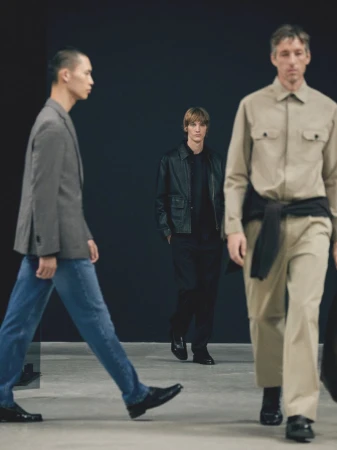 Three adult male models in contemporary menswear showcase walking poses in a studio setting, under neutral lighting, in a fashion editorial.
