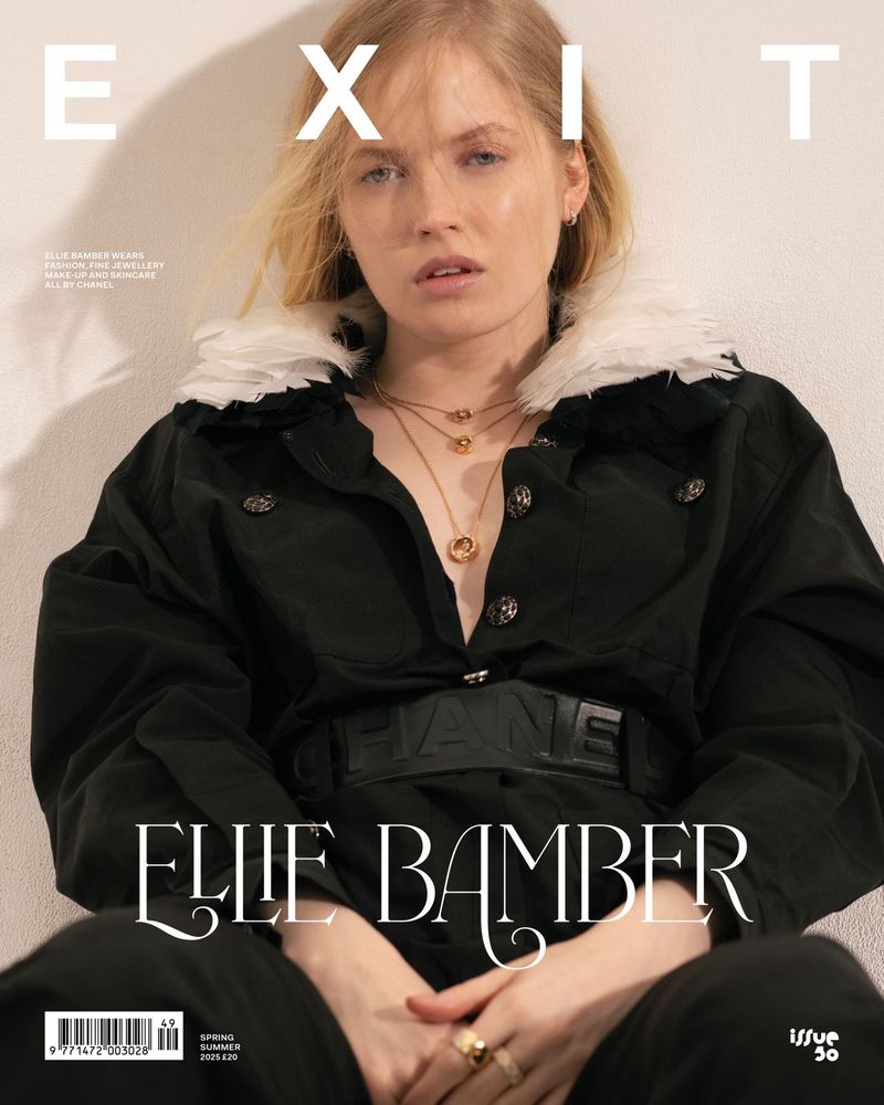 Fashion magazine cover featuring a young blonde woman with layered gold necklaces wearing a black coat with white faux fur collar.
