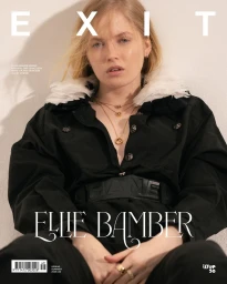 Portrait of actress Ellie Bamber wearing a black jacket with white feather collar for Exit Magazine S/S 25 cover