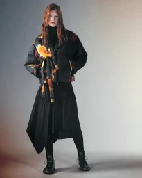 Model in black floral puffer jacket and long skirt against a gradient grey studio backdrop for Y-3 FW25