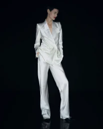 Model in white satin suit standing against a solid black background for Tom Ford S/S 2026
