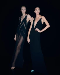 Two models wearing black evening gowns against a dark black seamless background for Tom Ford S/S 2026