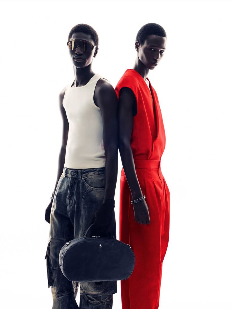 Two dark-skinned adult fashion models pose back-to-back against a white background in a studio setting, wearing casual and formal garments.