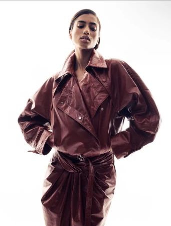Model wearing a brown leather belted jacket against a solid white background for Ferrari lookbook