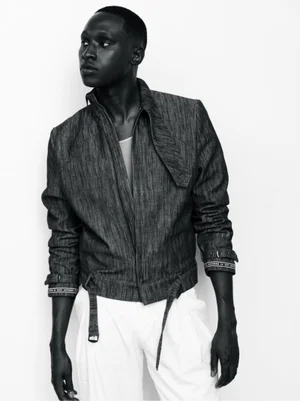 Black man wearing a textured jacket and white trousers against a plain white background for the Kent Anthony SS 26 lookbook