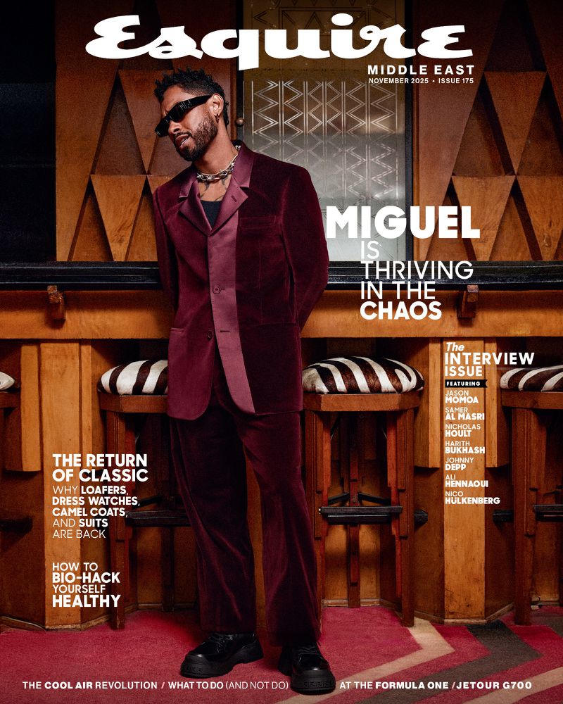Esquire Middle East magazine cover featuring Miguel in a burgundy velvet suit, standing against a backdrop of wooden panels and zebra-striped stools.
