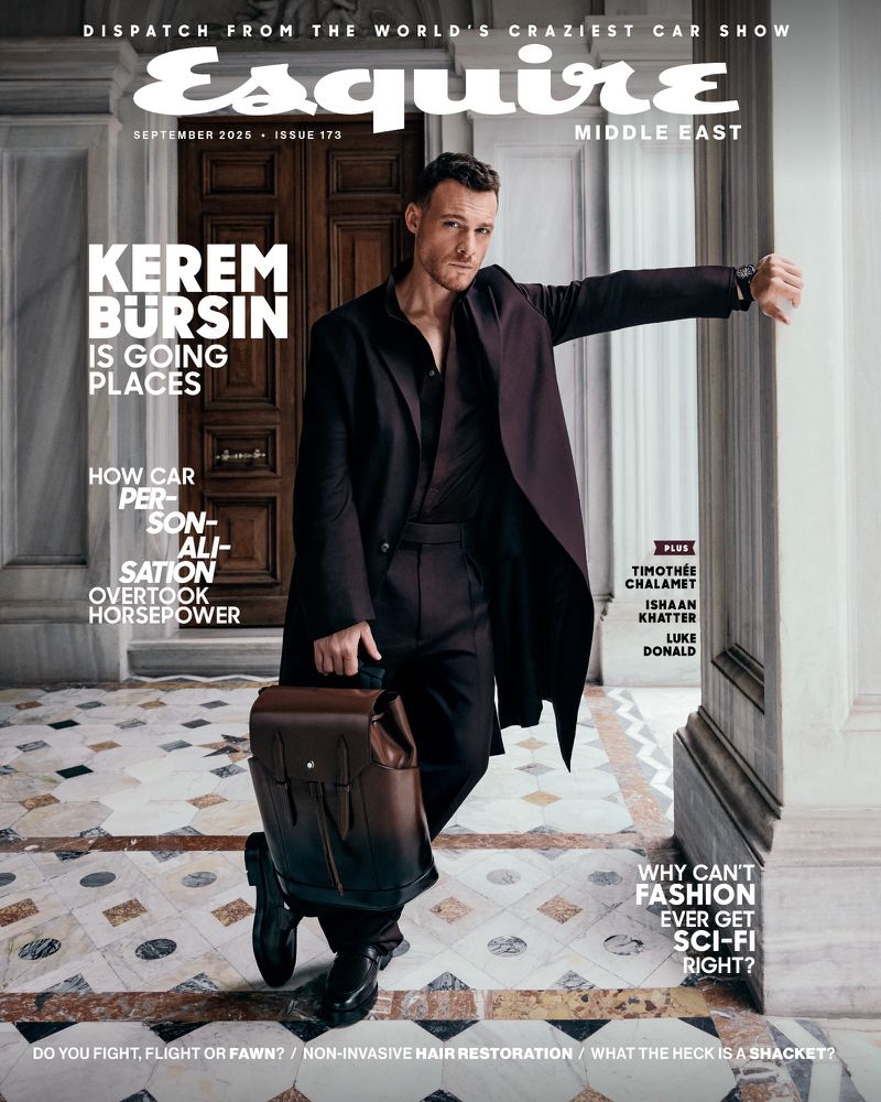 Esquire Middle East magazine cover featuring Kerem Bursin in a dark coat, holding a briefcase, with article headlines in the background.