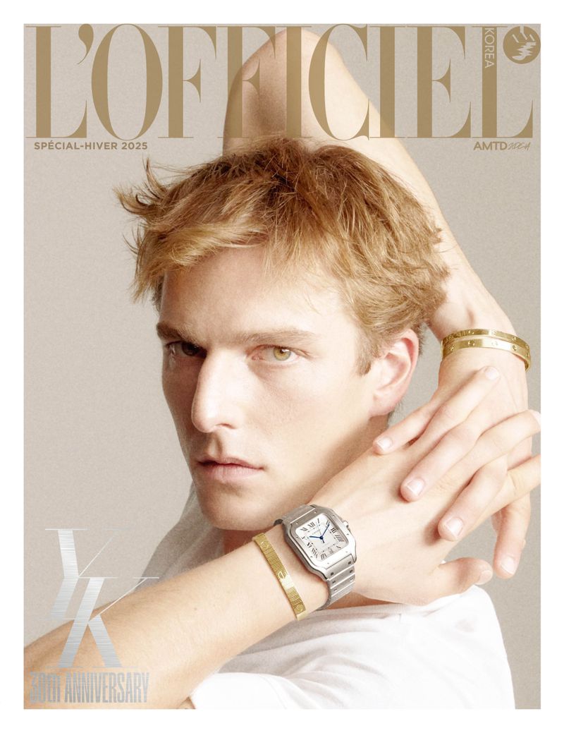 Magazine cover featuring a blonde male model wearing jewelry and a watch against a light background with neutral color tones.