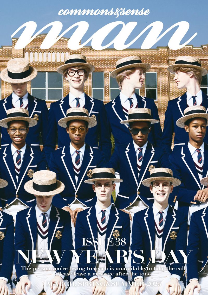 Magazine cover featuring a group of young men in blazers and straw hats, posing in front of a brick building on a sunny day.