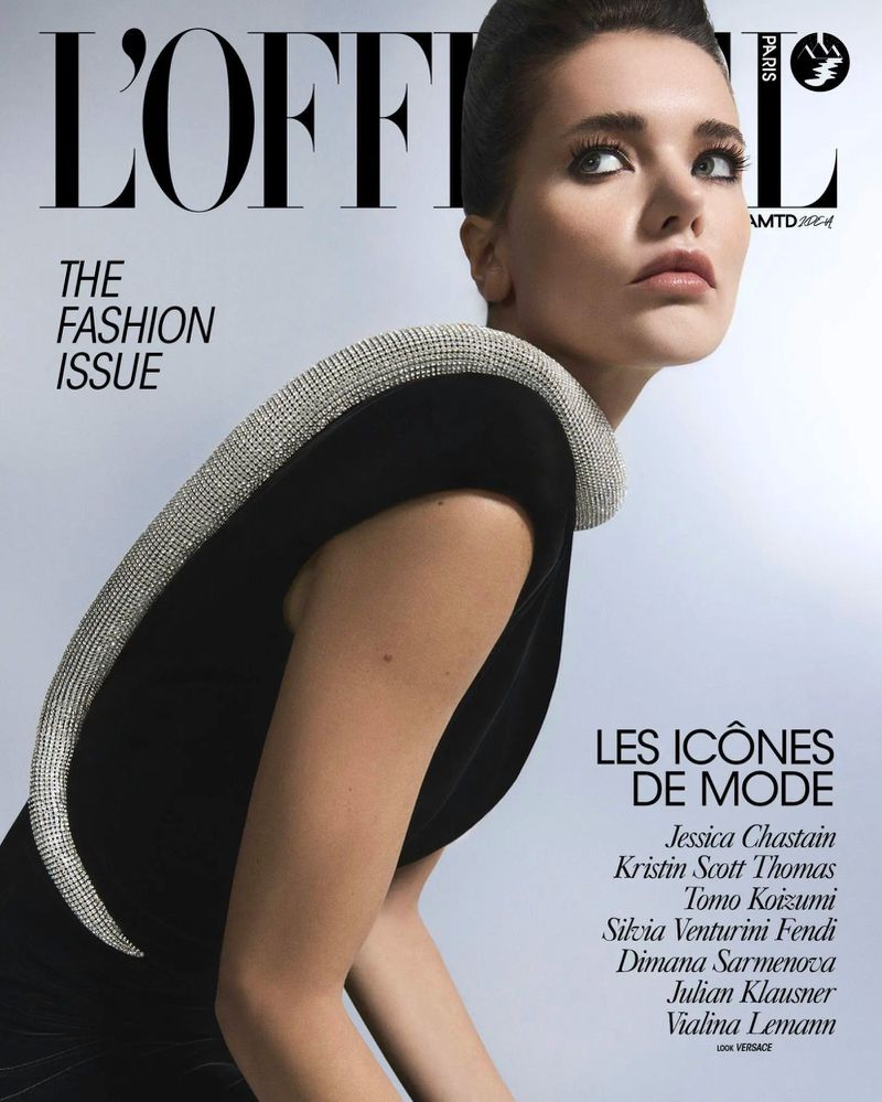 Fashion magazine cover featuring a woman in a black dress with a sparkling collar, looking up and to the side, with bold magazine text.