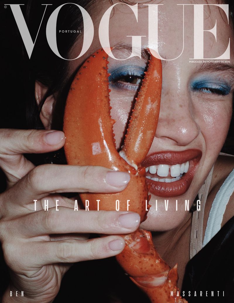 Vogue Portugal magazine cover featuring a woman smiling with dramatic blue eye makeup and holding a large lobster claw to her face.