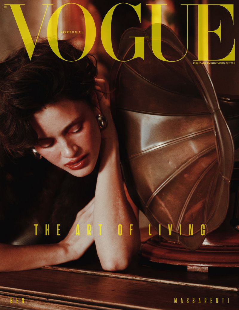 Vogue Portugal cover featuring a brunette woman resting her head on her arm next to a vintage phonograph in warm, moody lighting.