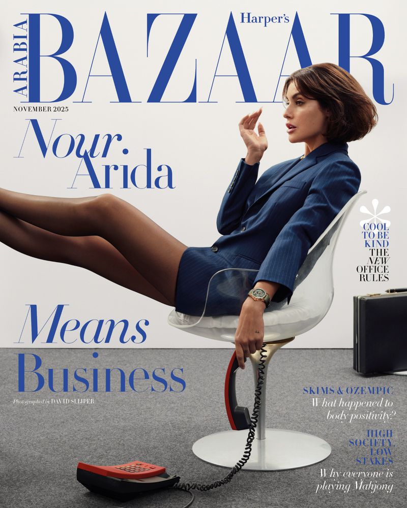 Harper's Bazaar cover featuring model Nour Arida in a blue suit sitting on a clear chair, with a retro telephone in the foreground.