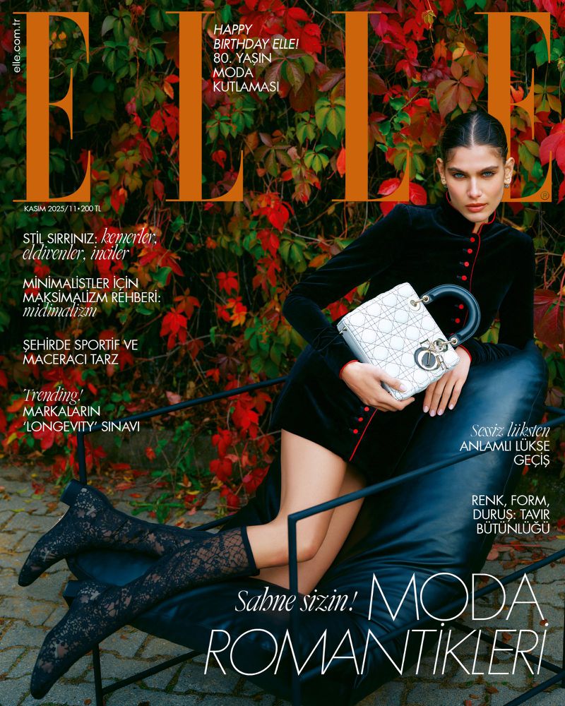Elle magazine cover featuring a model in a black dress and lace stockings, holding a white handbag with an autumn leaves background.