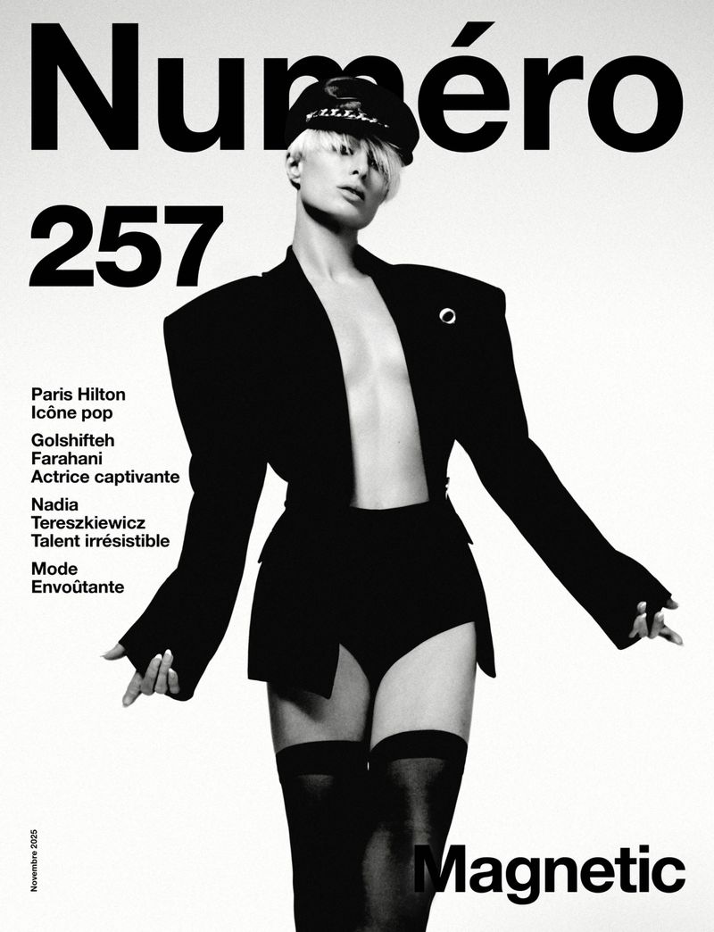 Magazine cover featuring a light-skinned adult female with a platinum blonde pixie cut, wearing a black jacket and bottoms on a white background.
