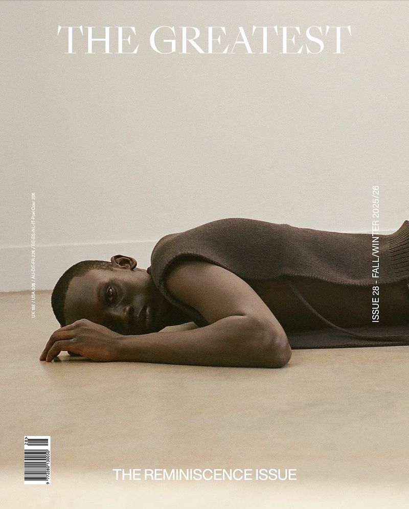 Magazine cover features a Black male model lying on a neutral floor wearing a brown sleeveless top, with magazine text and graphics.