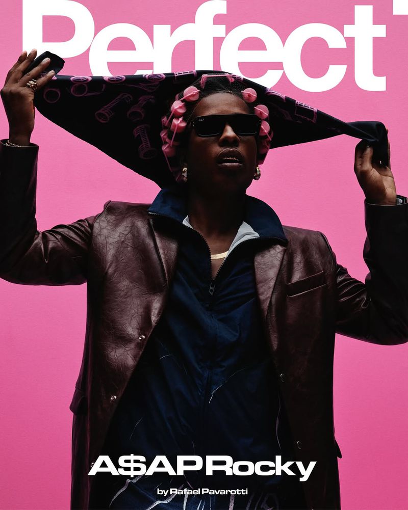 Portrait of A$AP Rocky on the cover of Perfect magazine with pink background, wearing sunglasses, jacket, and hair rollers.