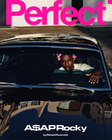 A$AP Rocky sitting inside a black classic car wearing pink hair rollers, photographed for The Perfect Magazine.