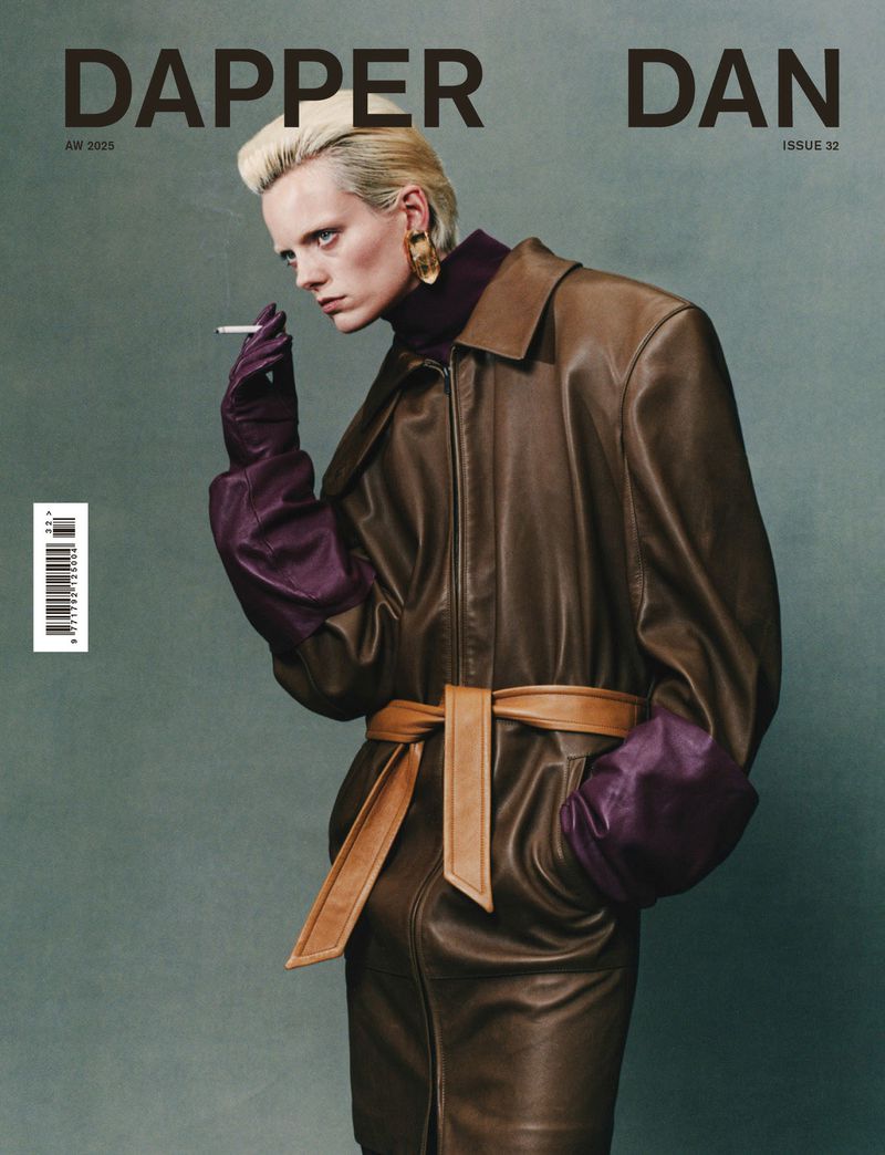 Dapper Dan magazine cover featuring a model in a brown leather trench coat, purple gloves, gold earrings, and holding a cigarette.