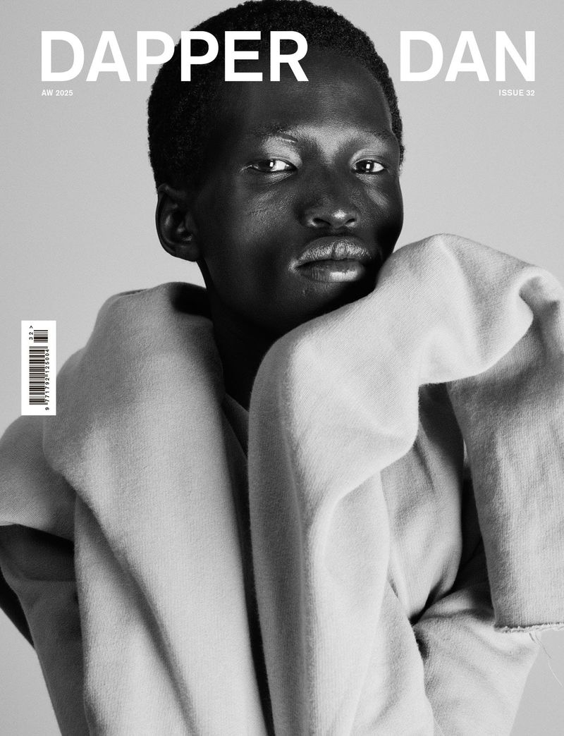 Black and white portrait of model Mamuor Majeng draped in thick fabric on the cover of Dapper Dan Magazine.