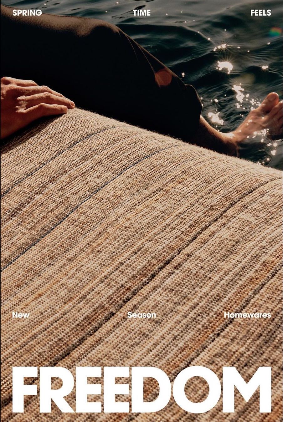 Close-up of a person resting on a textured woven lounge cushion next to dark water under sunlight.