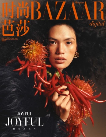 Fashion magazine cover featuring a woman with dark curly hair, red flowers, and a black furry shawl, overlaid with 'BAZAAR' and 'JOYFUL' text.