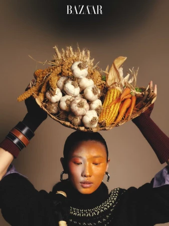 Model holding a basket of harvest vegetables on her head for Harper's Bazaar China November 2025 digital cover.
