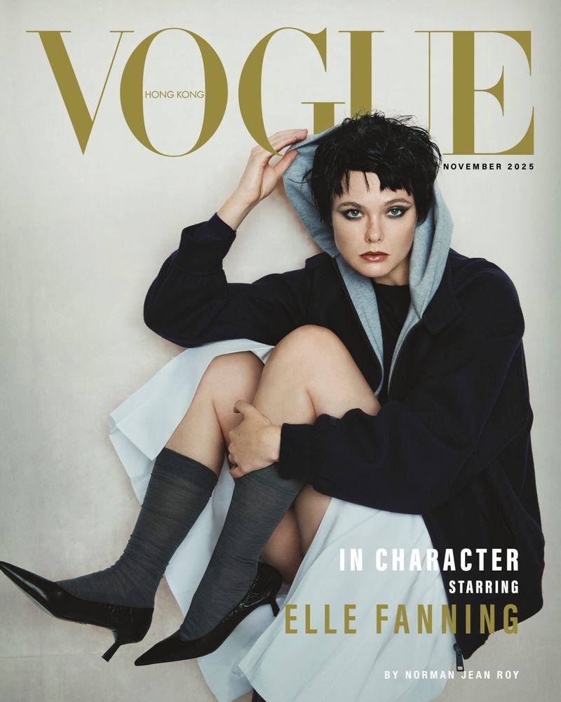 Vogue Hong Kong cover November 2025 features Elle Fanning in a hooded jacket, skirt, socks, and heels against an off-white background.