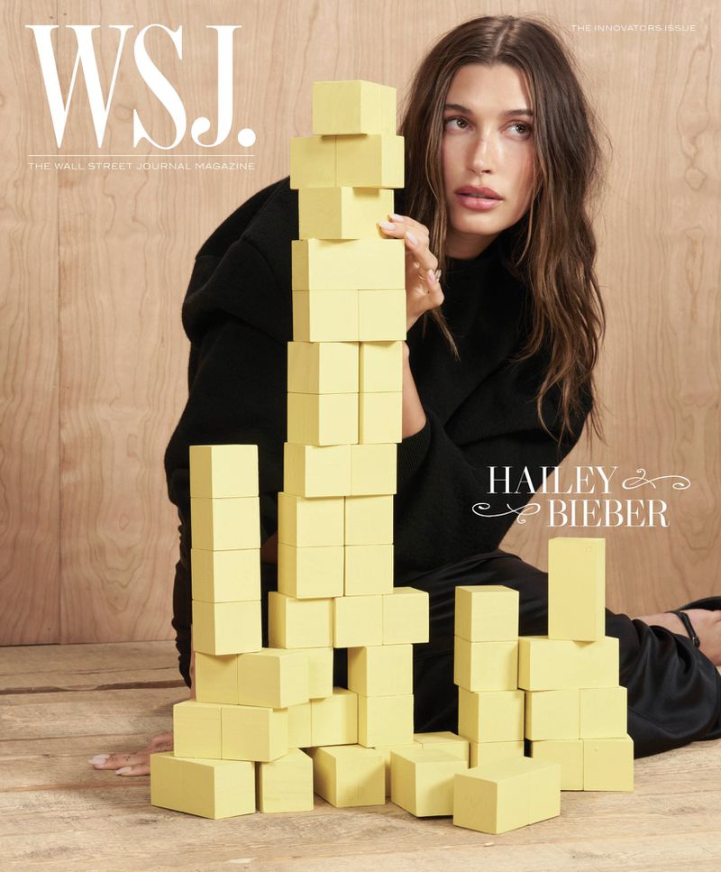 Magazine cover featuring Hailey Bieber with geometric yellow blocks, set against a wood background. The Wall Street Journal logo is visible.