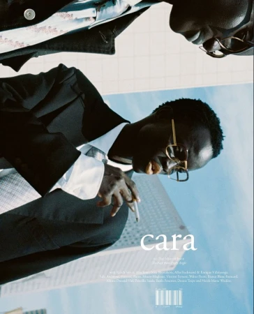 Fashion editorial shot of two Black male fashion models wearing blazers and glasses, with buildings in the backdrop.