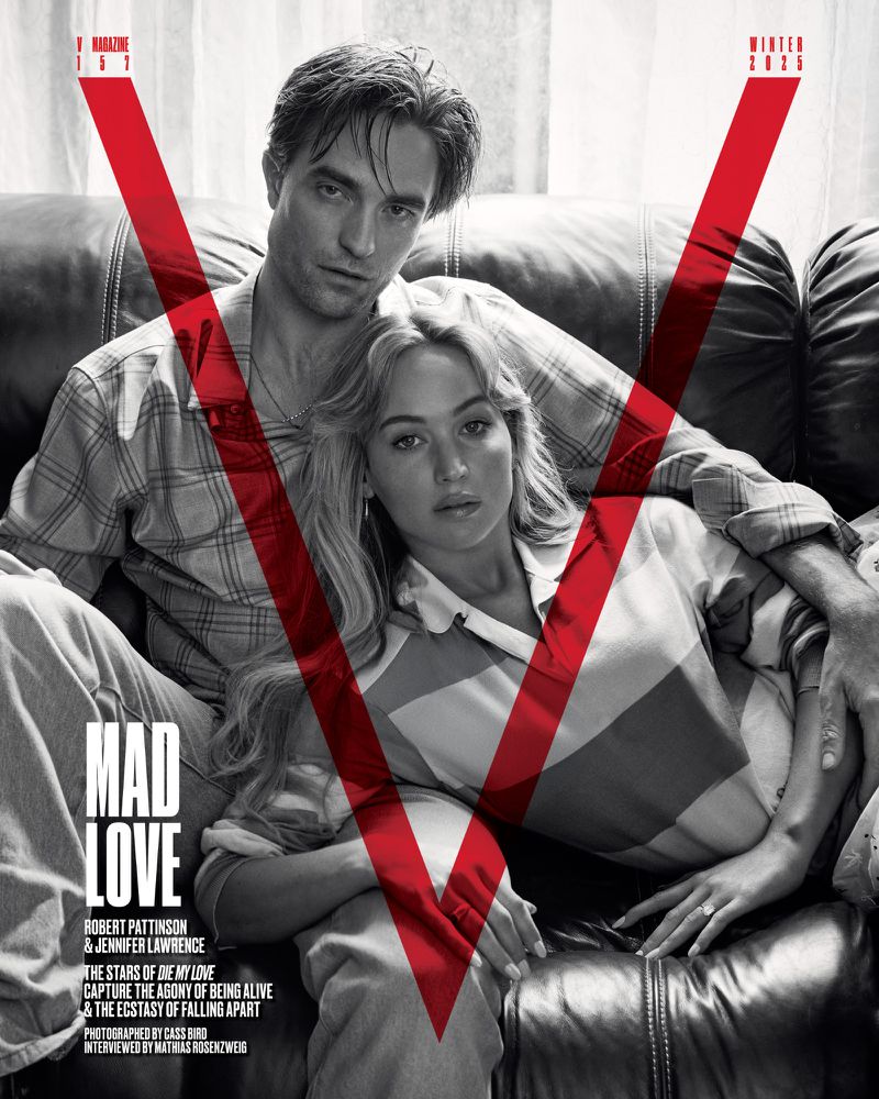 Fashion magazine cover featuring Robert Pattinson and Jennifer Lawrence in a close embrace, styled in casual striped tops on a leather couch.