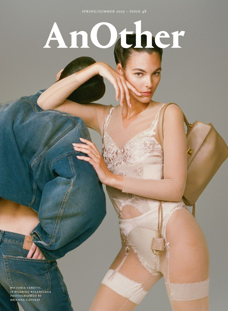 Editorial fashion shot featuring two fashion models in denim and lingerie in a photo studio setting with a neutral backdrop.