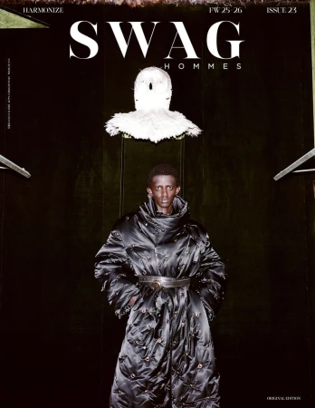 Editorial fashion shot of a Black man in a quilted black coat against a dark background, featured on the cover of SWAG Hommes magazine.