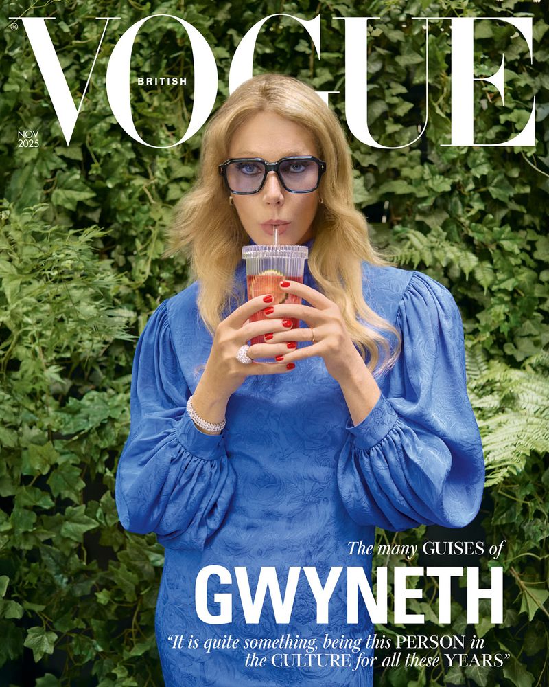 Vogue cover featuring a blonde woman in a blue dress drinking from a clear plastic cup with a straw in front of green foliage.