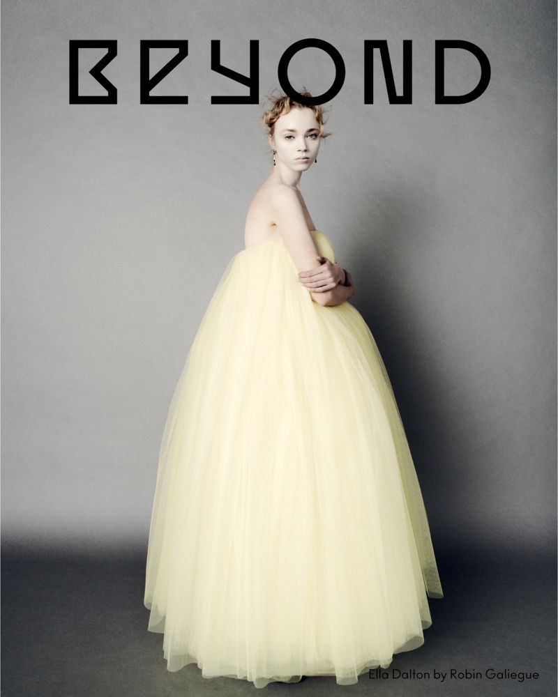 Fashion portrait of a young woman in a yellow gown against a grey background, BEYOND magazine cover.