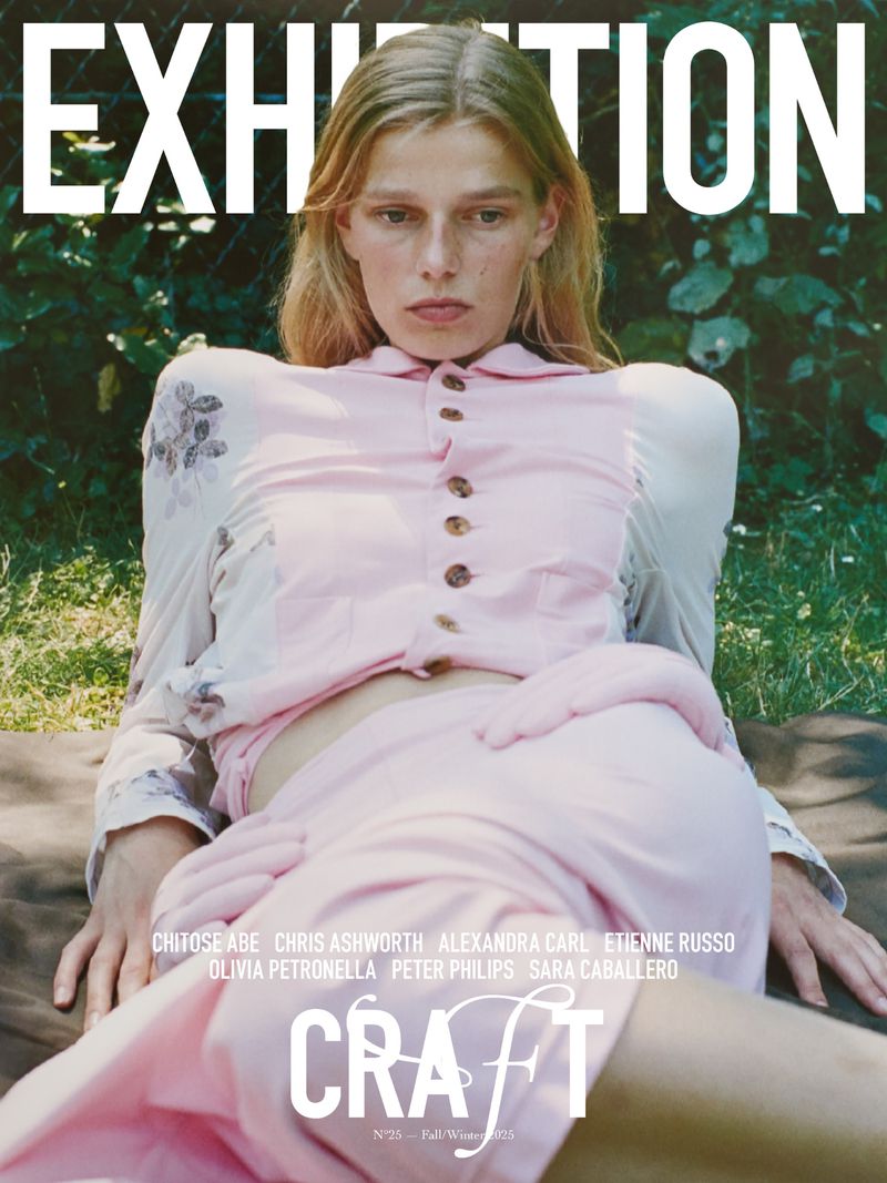 Magazine cover featuring a fair-skinned young adult woman with blonde hair in a pink outfit, lying in a grassy outdoor setting.