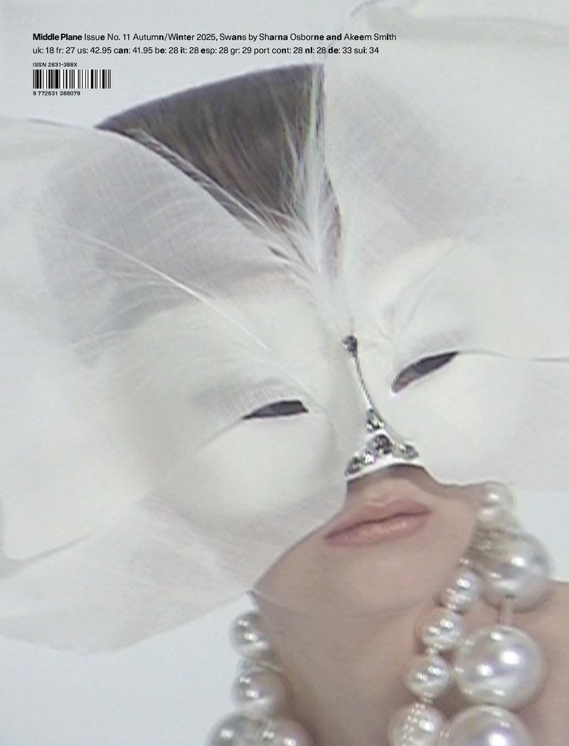 Woman wearing pearl necklace and white masquerade mask with feather, studio shot. Fashion, beauty, and portrait photography.