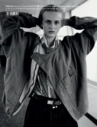 Black and white magazine cover featuring a model in an oversized jacket posing with hands behind the head.