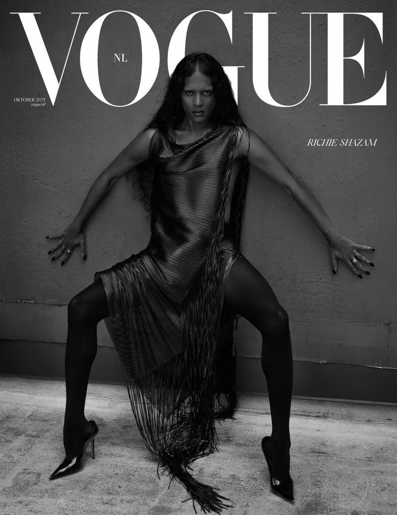 Vogue NL cover featuring a slender adult female in a glittering fringe dress, black hosiery, and heels, posing against a textured wall.