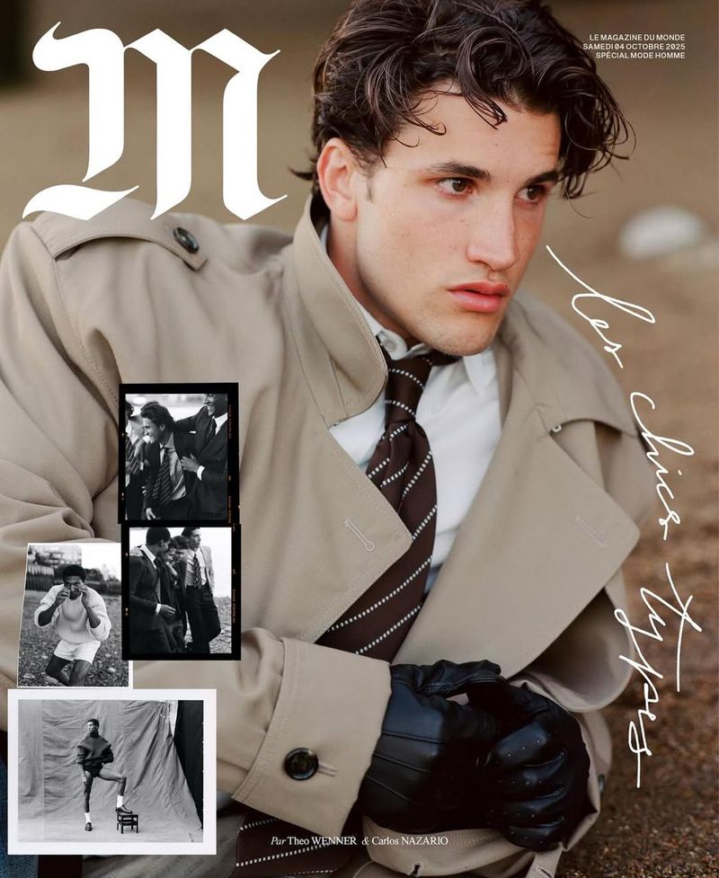 A fashionable young man wearing a tan trench coat with black leather gloves poses for a magazine cover with a neutral backdrop.
