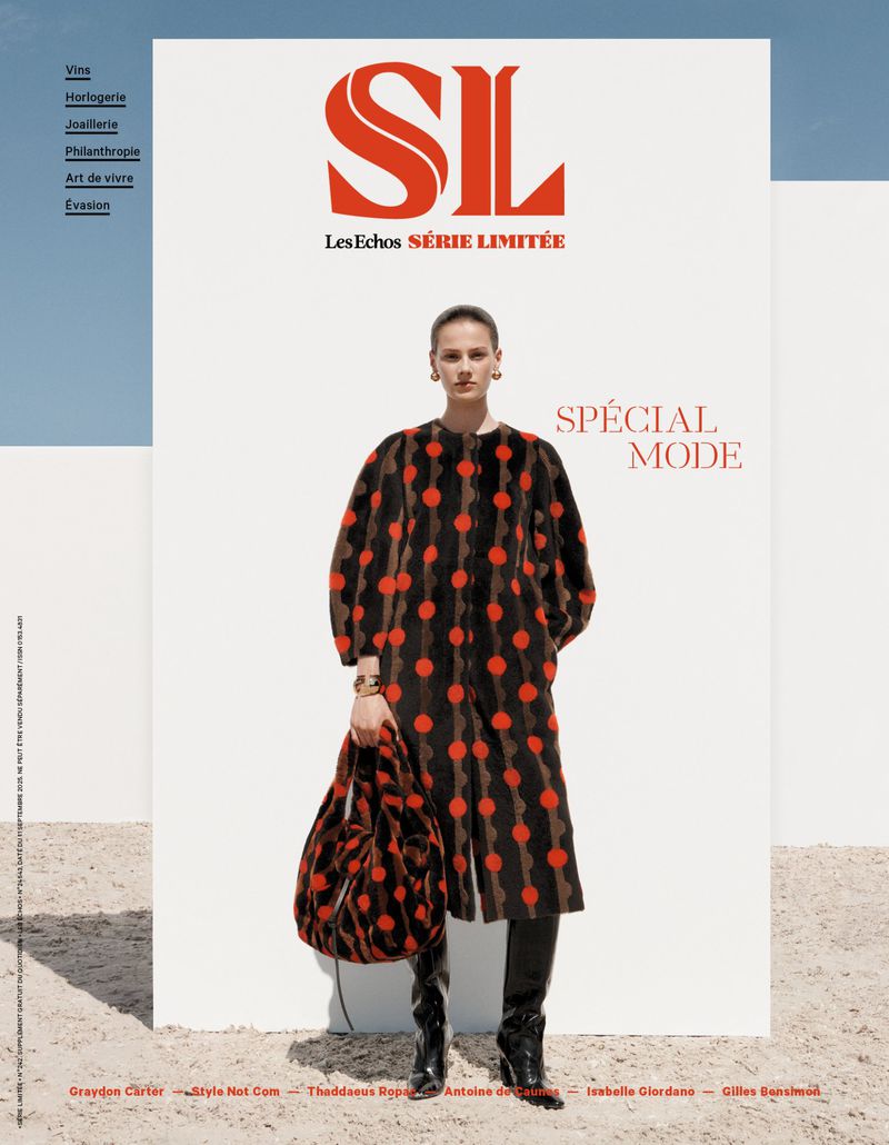 Fashion magazine cover featuring a woman in a polka-dot coat with a matching bag, paired with black boots, standing in an outdoor setting.