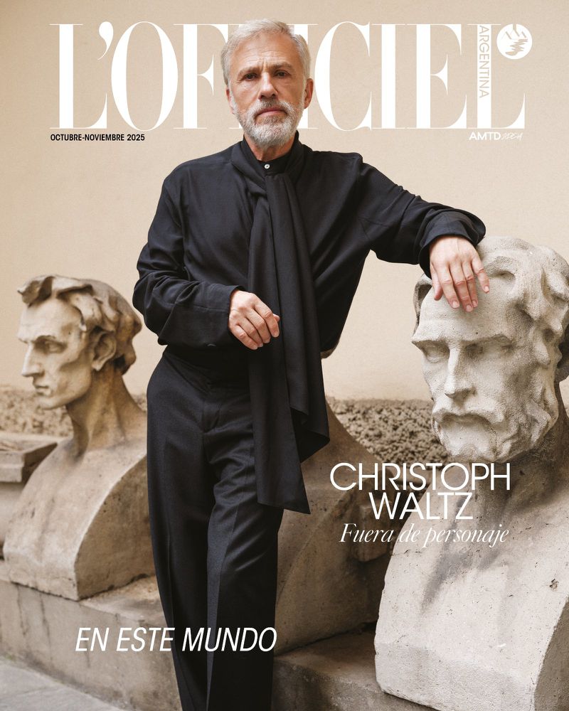 Christoph Waltz poses on a magazine cover with two antique bust statues. The magazine cover features the title L'Officiel Argentina.