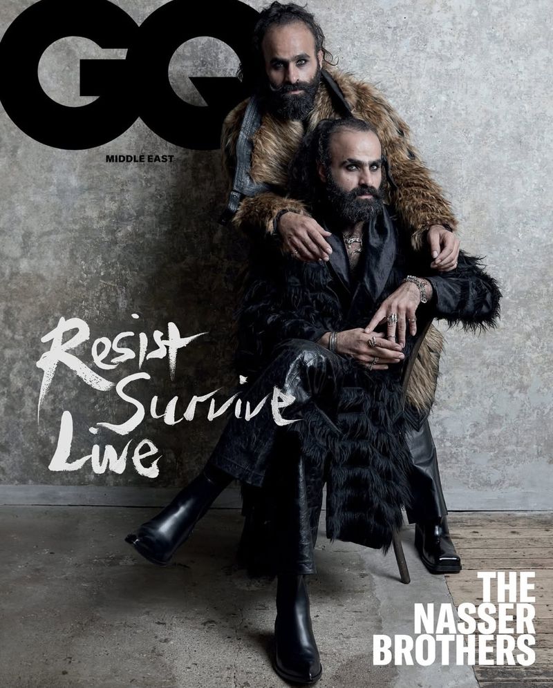 GQ Middle East magazine cover featuring two adult men, the Nasser Brothers, in fur coats, one seated, the other standing, posing indoors.