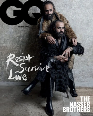GQ Middle East magazine cover featuring two adult men, the Nasser Brothers, in fur coats, one seated, the other standing, posing indoors.