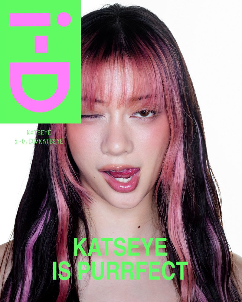 Close-up of a young adult woman with pink and black hair, winking and sticking out her tongue, with a bright green graphic element.