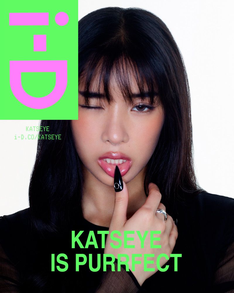 A young woman with dark hair winks at the camera while sticking her tongue out, with a green logo and promotional text overlayed.