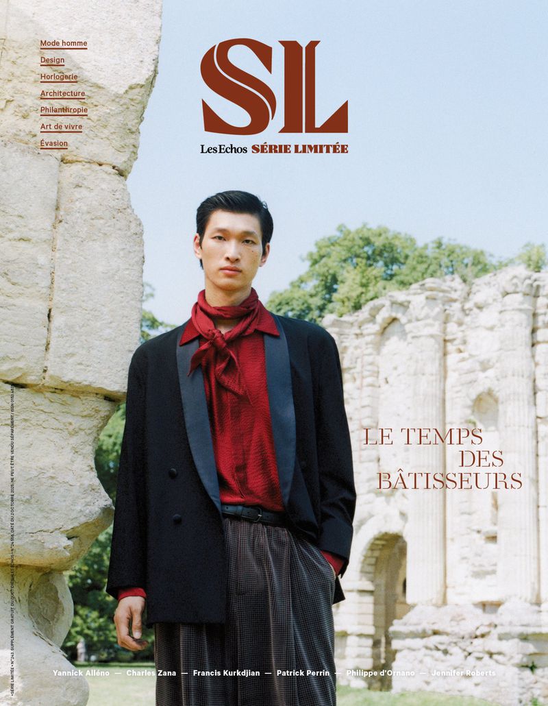 Magazine cover featuring an Asian male model wearing a black blazer and red shirt, posing against a backdrop of stone ruins and greenery.